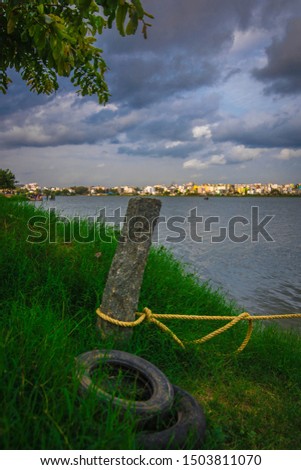 Yellow rope tied to a rock pole witha lying tyre on the grass
