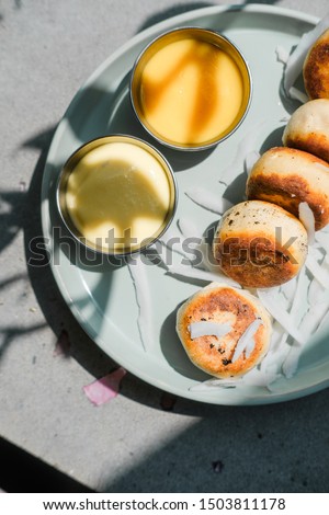 Vegan tofu cheese pancakes on blue plate, gray concrete table. Direct sun light, focus on shadows. Food blog photography concept. Overhead