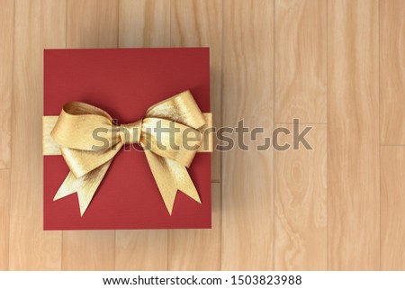 Red new year or Christmas gift box with golden ribbon for celebration concept on wooden board. with empty space for text and design, 3d illustration with clipping mask.