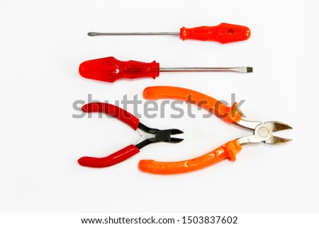 old rusty metal screwdrivers and pliers nippers with red a plastic handles
