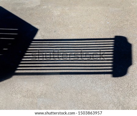 Shadows. Isolated Image .Part of garden table and chair creating an optical illusion. Stock photo.