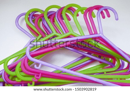 Colorful plastic hangers for adults and children's clothing. Pink, lilac and green on white background. The concept of shopping, sales, nothing to wear, children's clothing