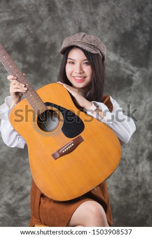 a cute girl with guitar music  at studio , fashion concept 