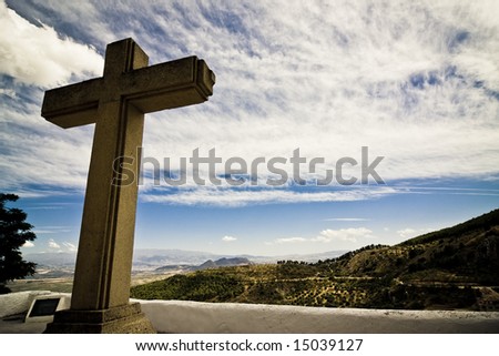 Christian cross in Mediterranean landscape, dramatically toned.