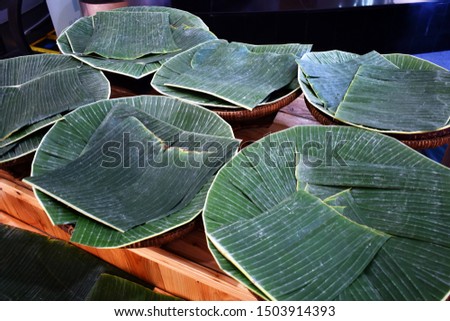 The banana leaf sheets were placed on the bamboo basket for holding Thai food and sweet .