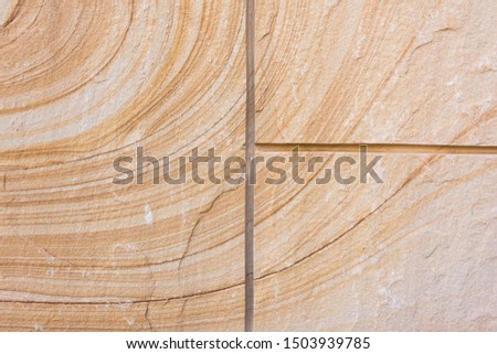 Orange spiral pattern and stripes on sandstone closeup
