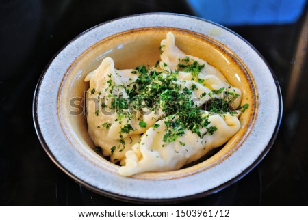 Mordovian style traditional Russian pelmeni dumplings made with minced meat and served with chopped dill Royalty-Free Stock Photo #1503961712