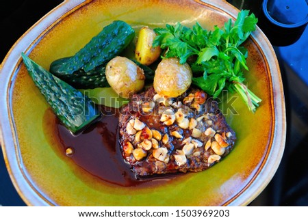 Traditional Mordovian Bear's Paw ("ovton lapat" or "ofton madyat") dish made with beef, beef liver and pork, and black bread crumbs, served with pickled cucumbers, baby potatoes and dill Royalty-Free Stock Photo #1503969203