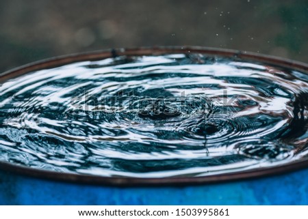 Drops of water slow motion. Dripping rain in a water barrel, time lapse photo background concept