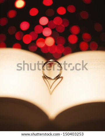 Ring on a book with a heart shadow