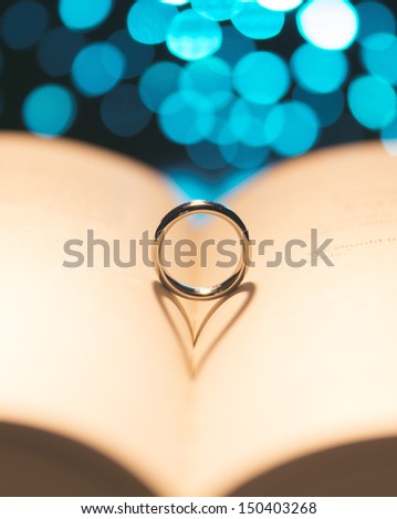 Ring on a book with a heart shadow