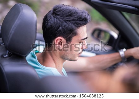 Arab man driving in convertible car on beautiful summer day and having fun.
