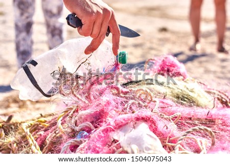 A tangled mess of fishing nets plastic rope and other debris washed up on a coastal beach. Save the Planet stock picture.