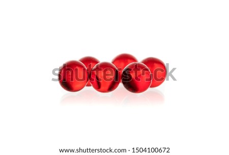 transparent white and red round small capsules with medicine on a black and white background