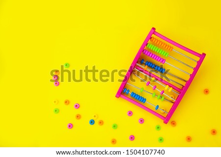 Educational colorful abacus beads for kids isolated on yellow background.Broken, learning equipment. Calculating thinking concept, with space for text