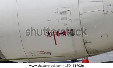 Photo of the warning messages, on the side of an aircraft turbine.
