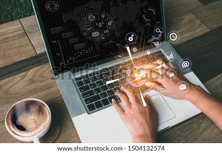Business hand using laptop sitting on table virtual icons graphics interface screen in morning light.
