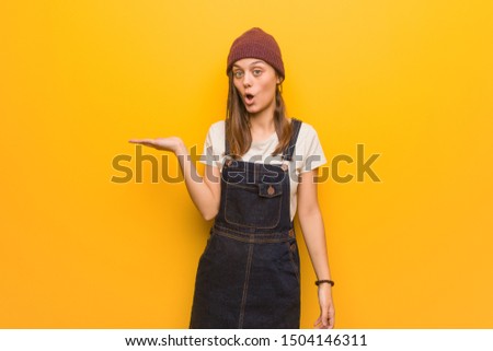 Young hipster woman holding something on palm hand