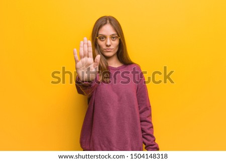 Young casual woman putting hand in front