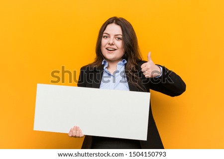 Young plus size curvy woman holding a placard smiling and raising thumb up