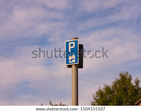 A blue parking allowed sign in London, photographed at sunset against a blue sky.