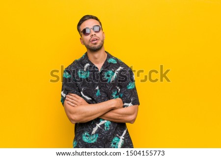 Young filipino man wearing summer clothes tired of a repetitive task.