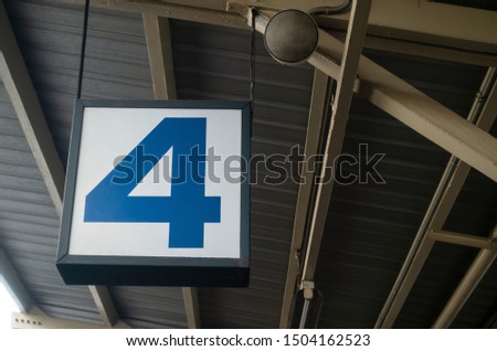 Number 4 display on hanging billboard or light box showcase on wall at airport or subway train platform station, signboard, transportation, advertisement, commercial and marketing concept