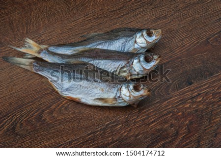 some dried fish on a dark wooden background/