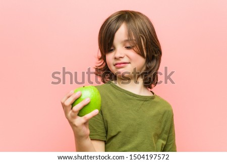Little caucasian boy holding an apple