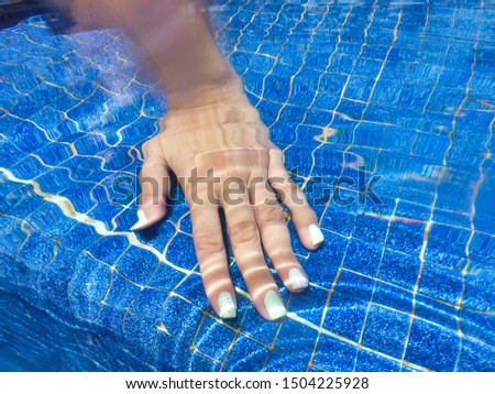 Woman hand in a pool under the water. Royalty-Free Stock Photo #1504225928