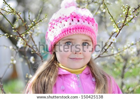 beautiful little girl near a flowering tree 