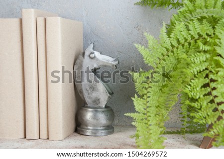 Antique book end in the shape of a chess horse on concrete background