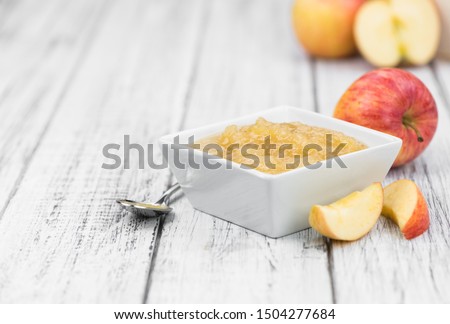 Old wooden table with fresh made Applesauce (selective focus; close-up shot) Royalty-Free Stock Photo #1504277684