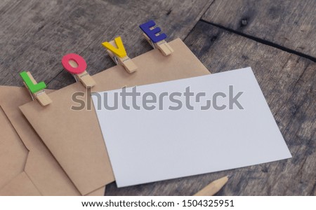 Envelope, white card and pencil with LOVE letter clips. Simple and minimal style for background and wallpaper. Love frame photo concept with copy space. Relationship idea of friendship and family.