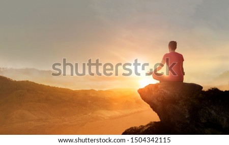 Woman practices yoga and meditating on the mountain sunset background. Royalty-Free Stock Photo #1504342115