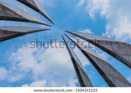 Curved, pointed spires of building reaching into beautiful partly cloudy blue sky.