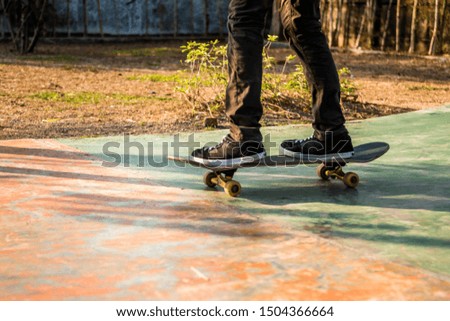 Young teenager feet playing skate board on a park