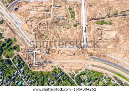 aerial top view of road construction site at suburb residential area with working building machines