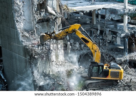 Excavator, digger taking down building  Royalty-Free Stock Photo #1504389896