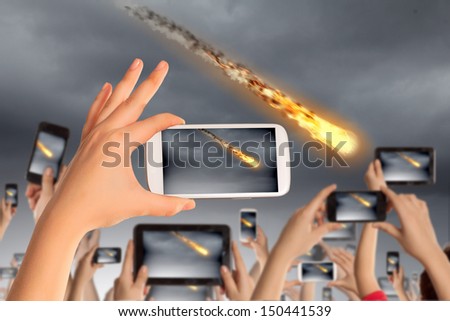 Close up of human hands taking photo of falling meteorite