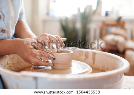 Female potter making a pot on pottery wheel
