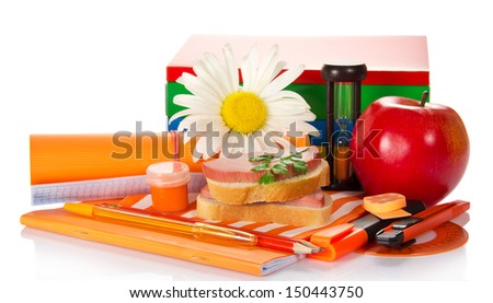 Writing materials, books, a paint, hourglasses, sandwich and apple on the striped napkin, a camomile, isolated on white