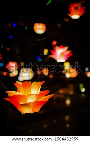 Decorated colourful hanging lights at night during festival season in India. Selective focus vertical picture of vibrant lights with dark blurred background.