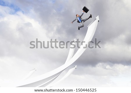 Young businessman jumping on white arrows. Growth concept