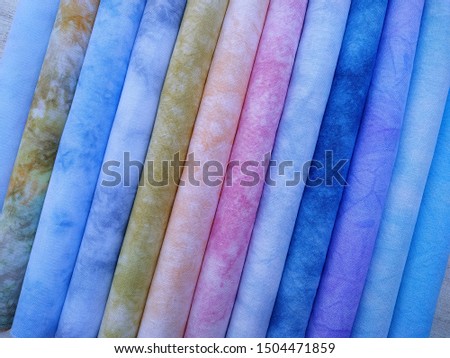 Rolls of colorful fabrics. Dyed fabric for sewing. Cross stitch fabric