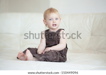 Picture of a baby sitting on a sofa at home