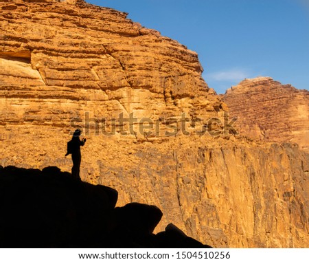 Unrecognisable silhouette of the somebody who is taking pictures in the moutains 