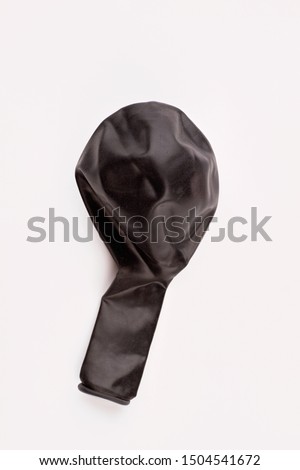 Black balloon without air. New balloon isolated on white bacground. Object for birthday party decor.