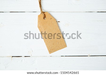 price tag label on wooden background One paper blank tags with rope on wooden background.
