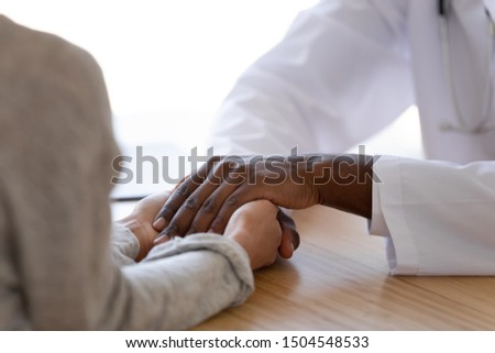 Close up African American doctor supporting female patient, holding hands at hospital, expressing support and care, woman received bad news and medical checkup results, medical ethics and empathy Royalty-Free Stock Photo #1504548533